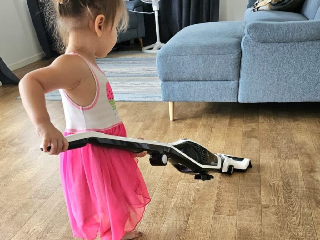 Young child vacuuming the house.