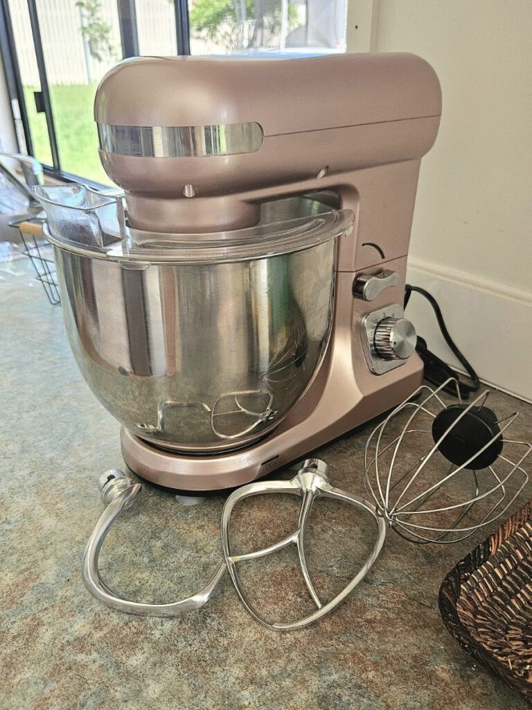 A pink kitchen aid on the bench.