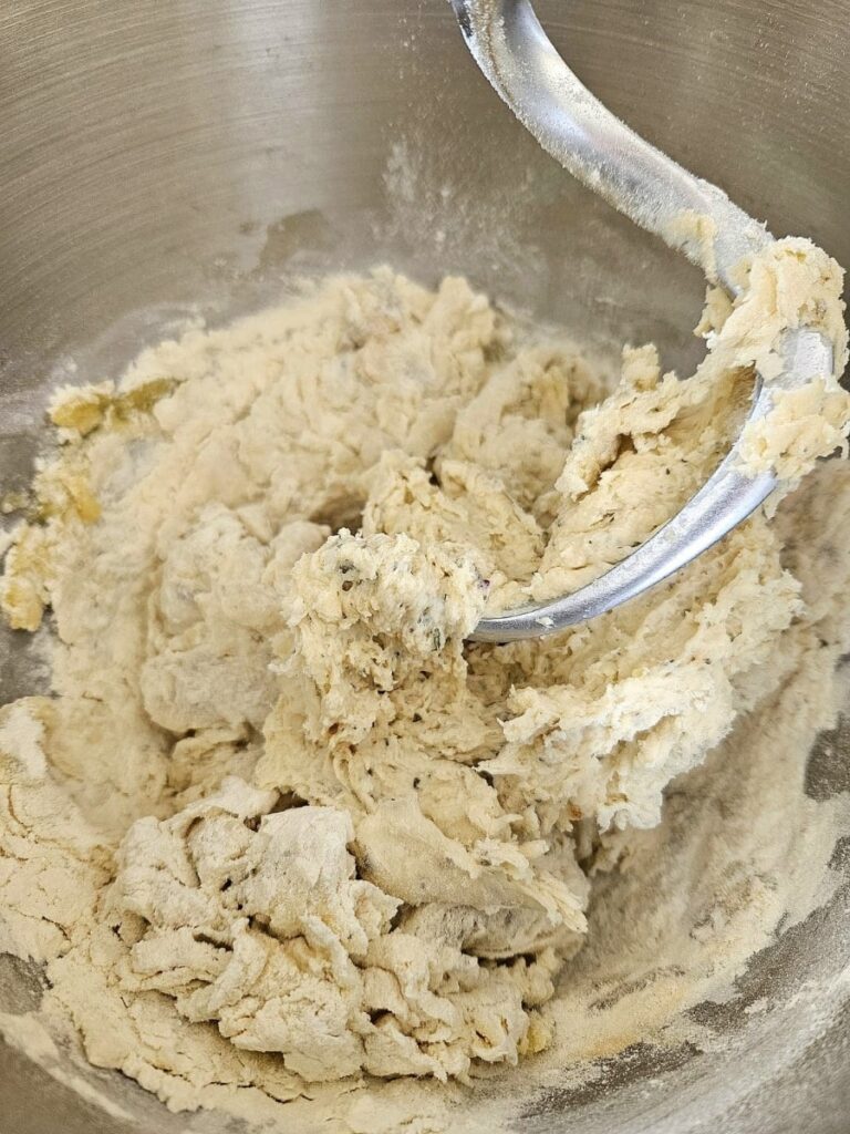 Mixing sourdough garlic bread ingredients to form a dough.