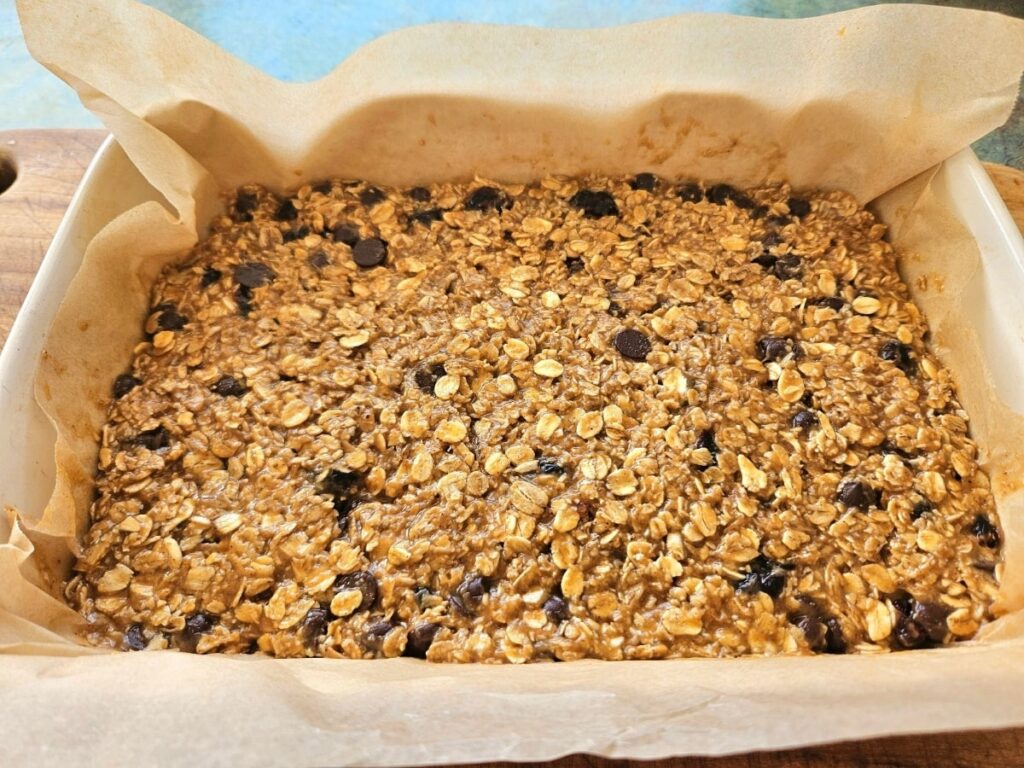 Granola bar mixture spread in a baking tray.