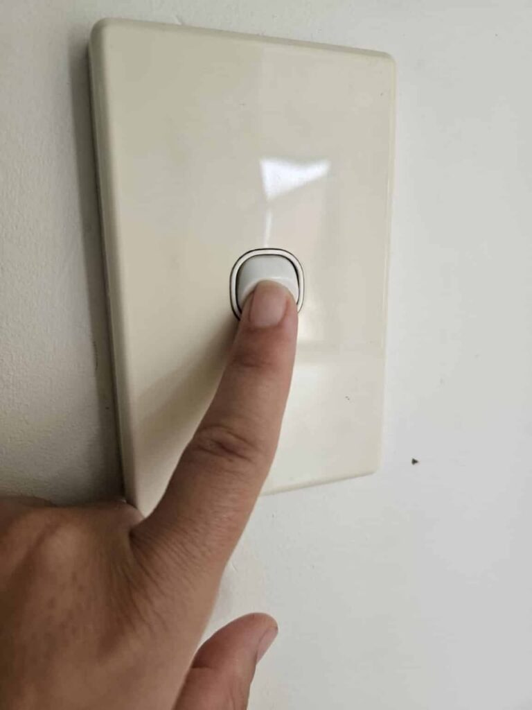 Turning off the light switch to save money.