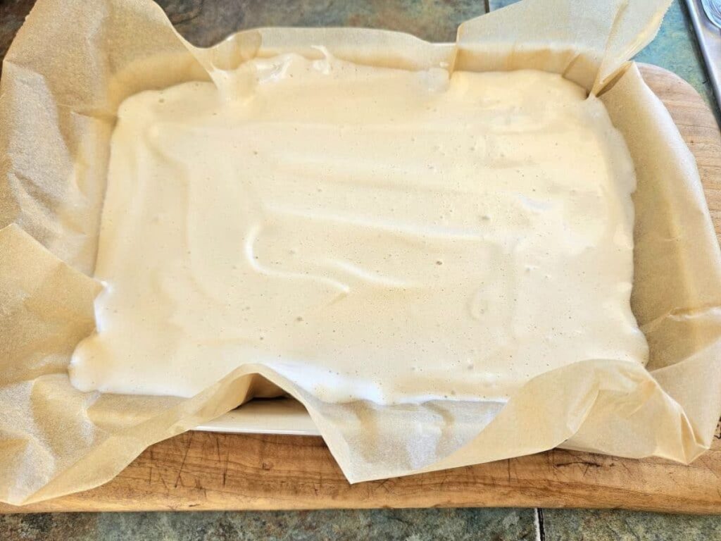 Setting homemade marshmallows in a baking dish.