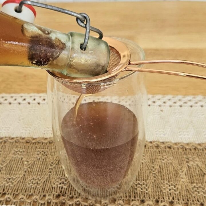 Pouring water kefir into a cup.