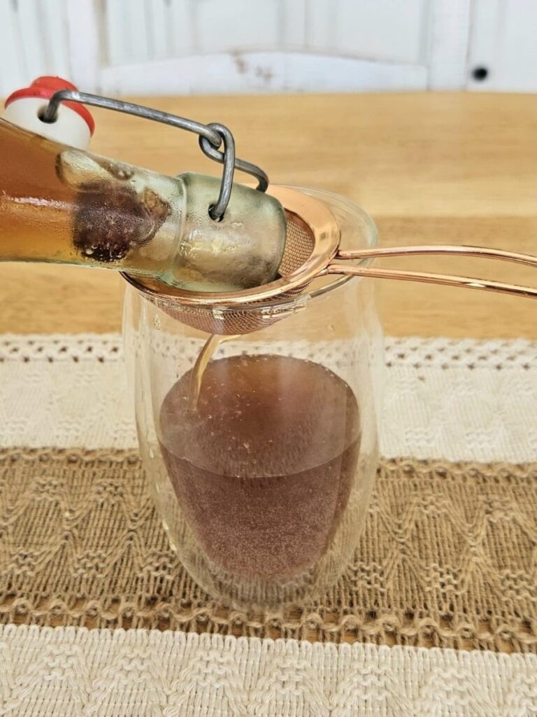 Pouring water kefir into a cup.