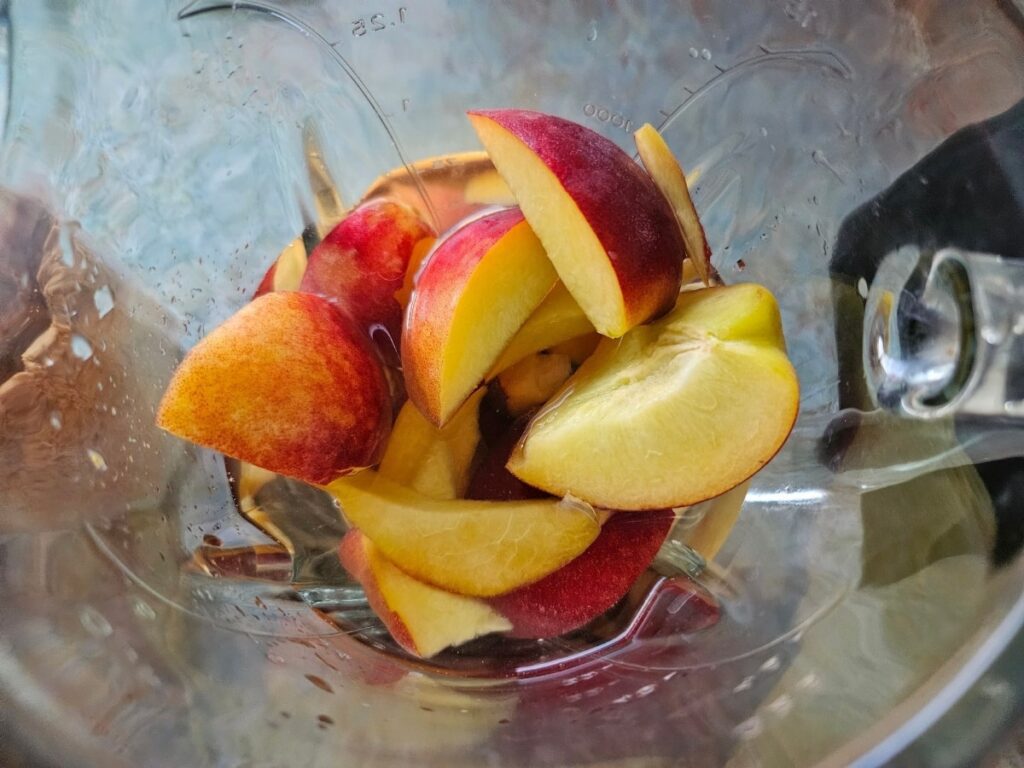 Blending peaches for peach iced tea.