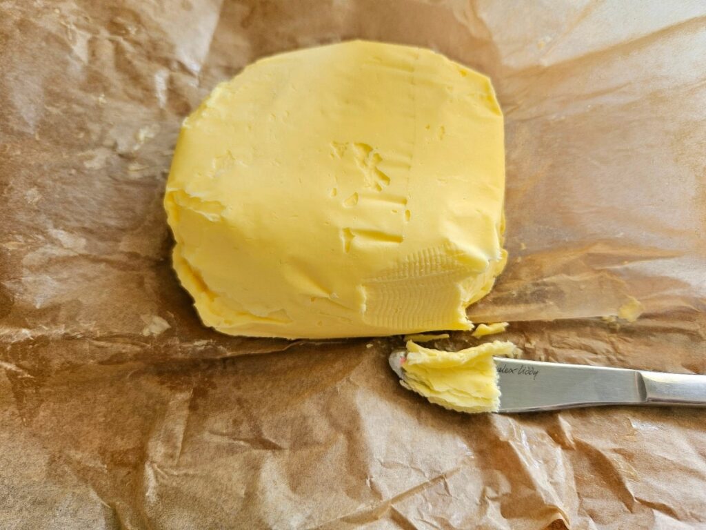 Homemade butter hardened and on a knife.