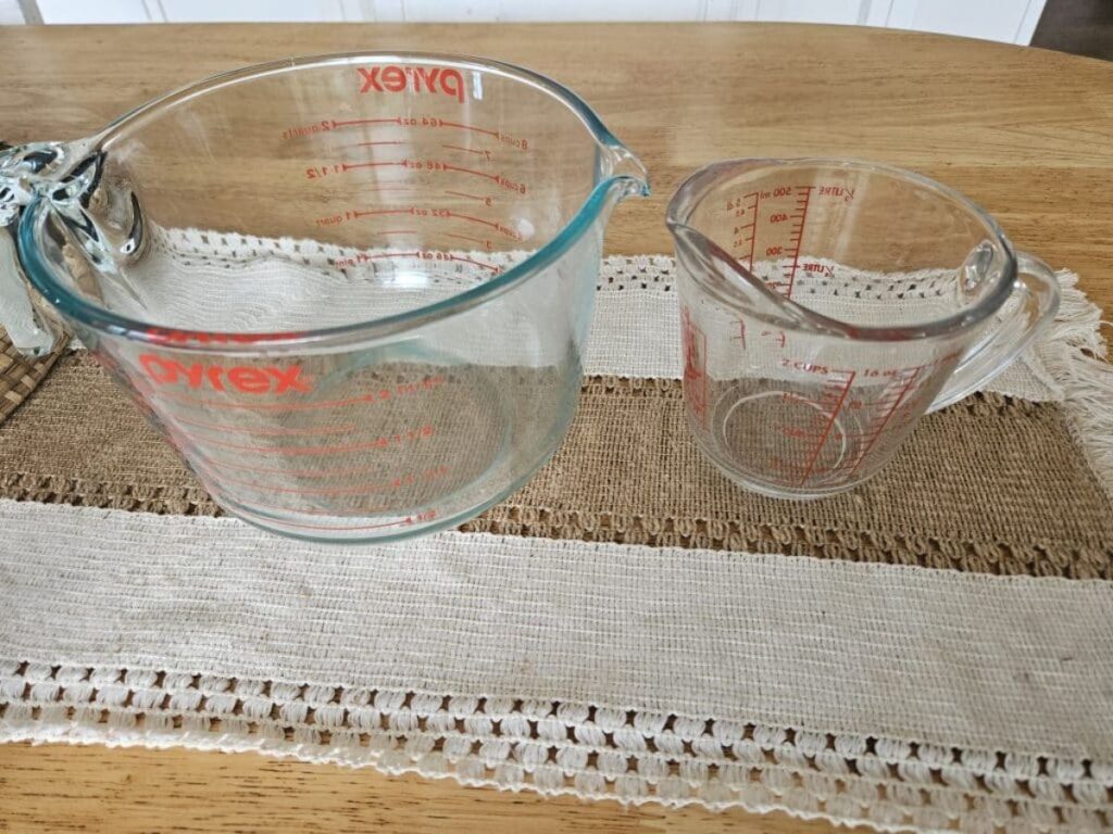 Glass pyrex measuring cups on a table.