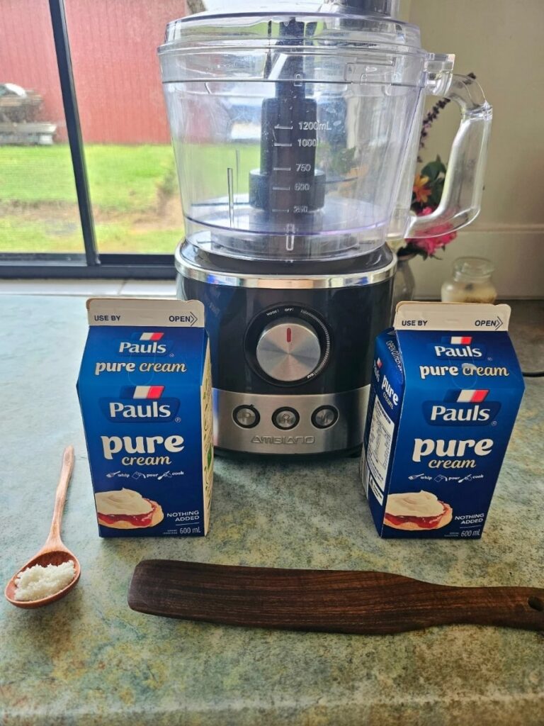 Supplies needed to make homemade butter on a bench top.