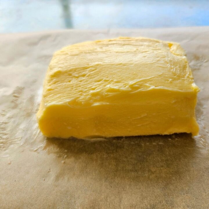 Homemade butter on wax paper being ready to be stored.