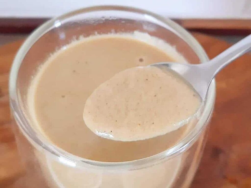 Creamy homemade Eggnog on a spoon.