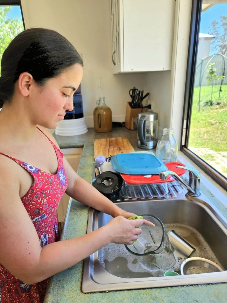 Women washing dishes in the sink.