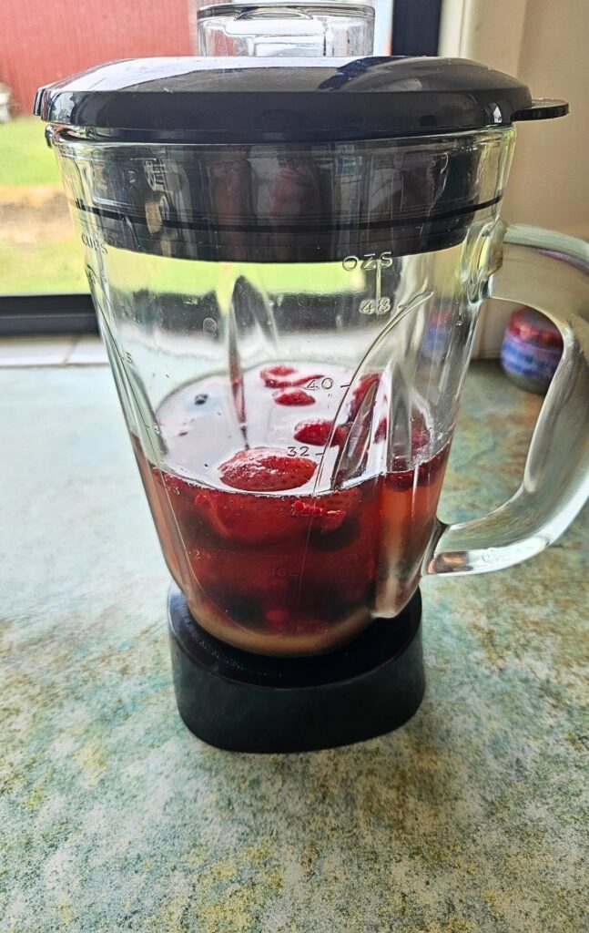 Blending ingredients to make berry iced tea.