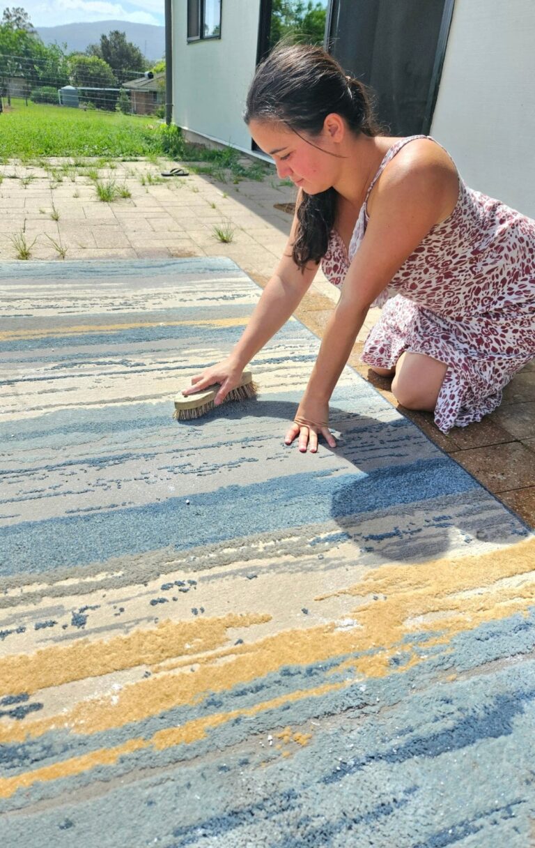 Cleaning rug outside for spring cleaning.