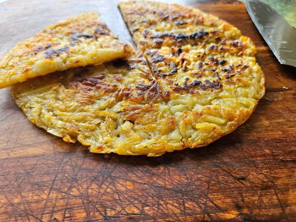 Crispy homemade hash brown on a cutting board.