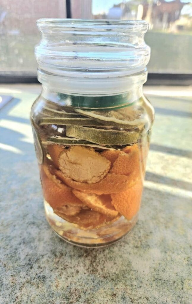 Making all purpose vinegar spray. Dehydrated citrus in a jar with vinegar.