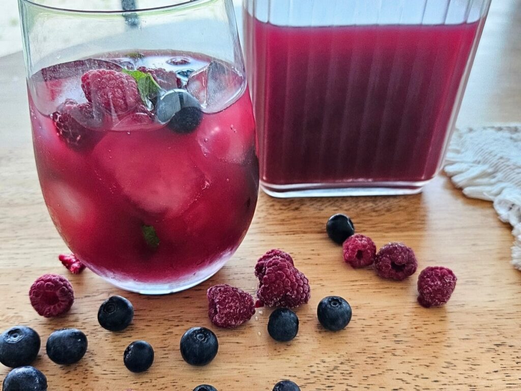 Homemade berry iced tea on a cutting board in the kitchen.