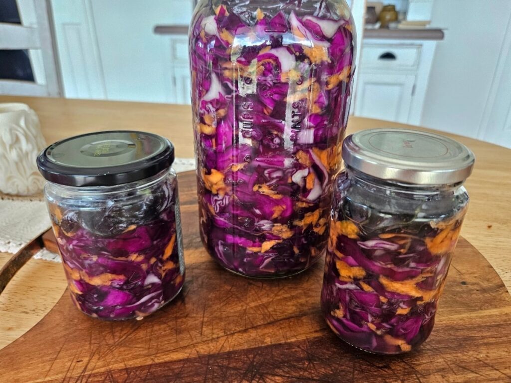 Homemade sauerkraut in a jar on the kitchen bench.