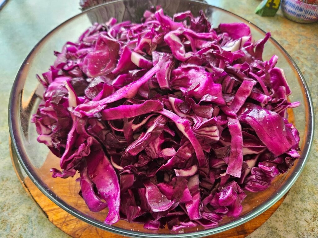 Shredded cabbage in a bowl with salt for fermenting.