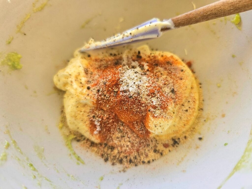 Sour cream mixture in a bowl for bean dip.