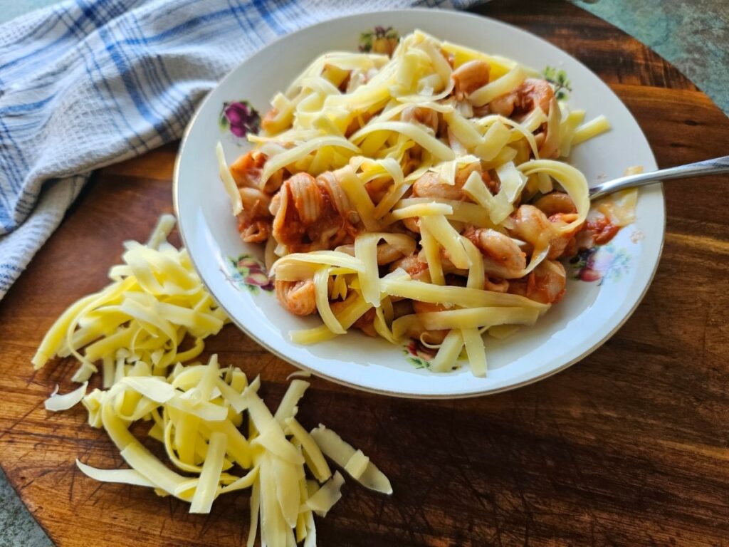 Homemade canned tuna pasta in a bowl on top of a cutting board.