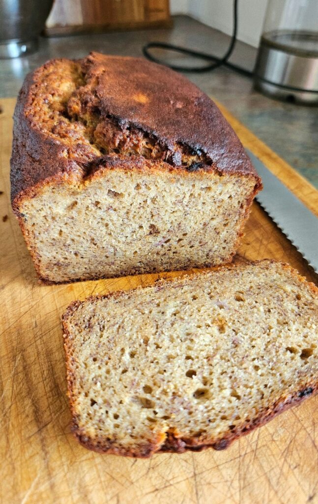 Soft, sliced banana bread on a cutting board.