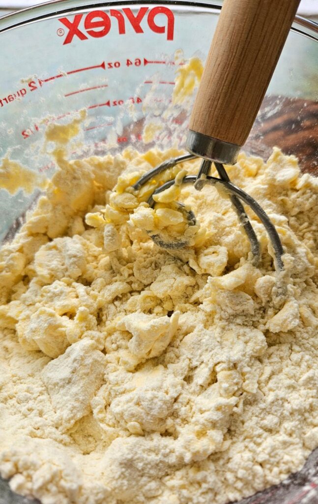 Mixing sourdough pie crust ingredients in a large glass pyrex measuring bowl.