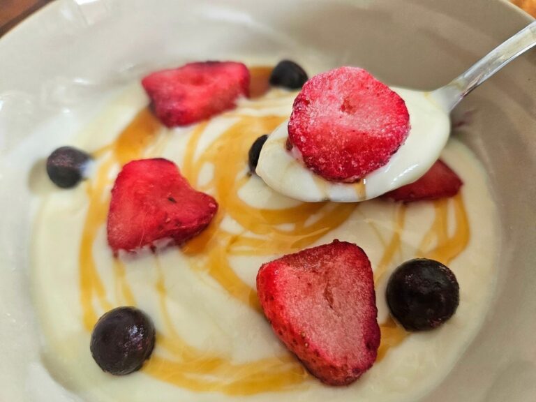 Homemade yoghurt in a bowl with berries and honey.