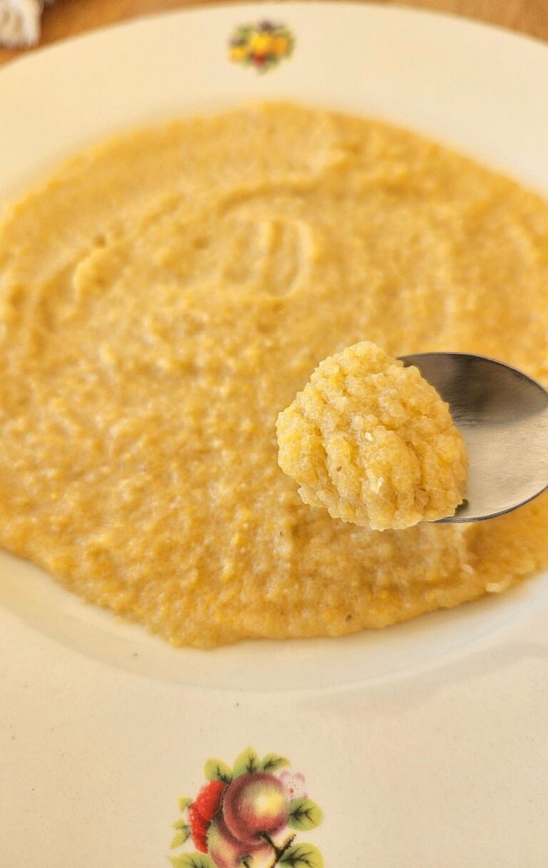 Creamy homemade polenta on a plate on the table.
