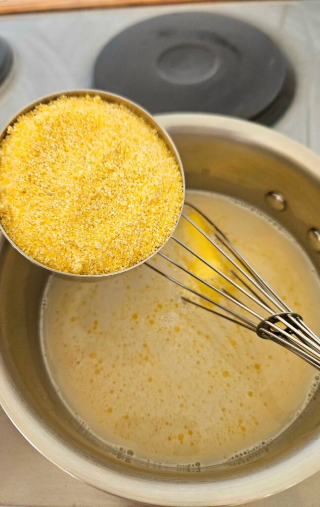 Making homemade creamy polenta recipe in a pot.