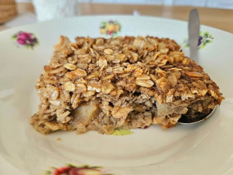 Baked apple and orange oatmeal in a bowl with spoon.