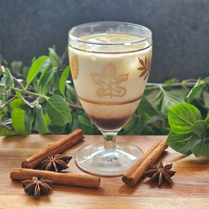 Chai latte with spices om a cutting board.