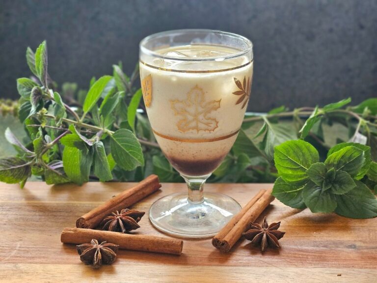 Chai latte with spices om a cutting board.