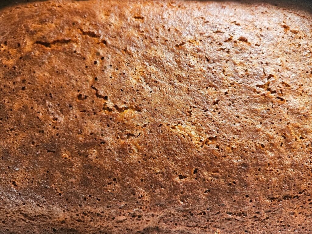Cooked carrot cake resting in baking tray.