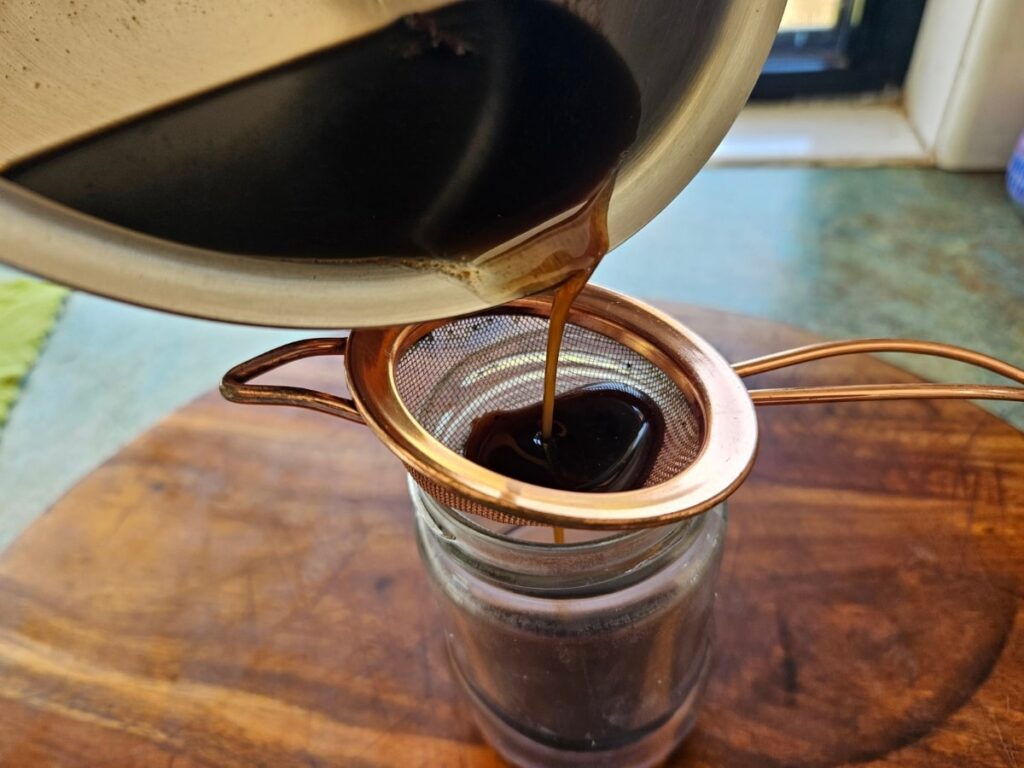 Straining chai syrup.