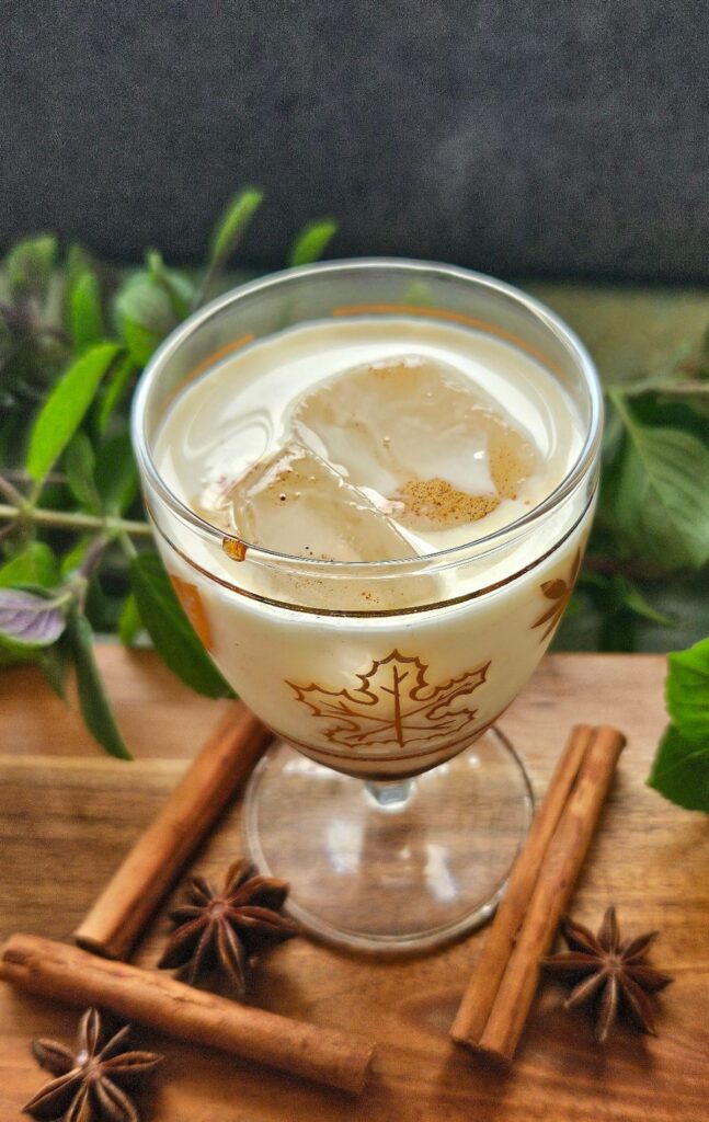 Chai latte made with chai syrup in a glass cup.