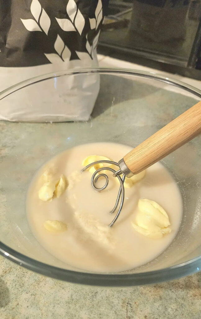 Hamburger bun ingredients in a bowl being mixed.