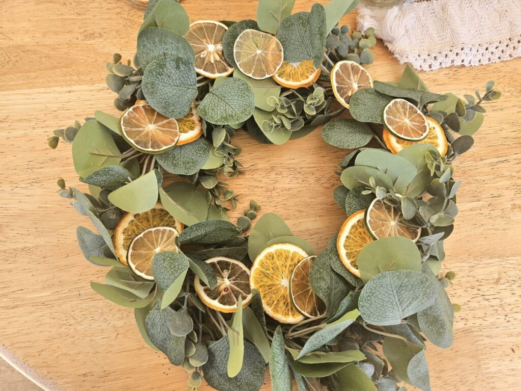 Homemade wreath with dried citrus on a table.