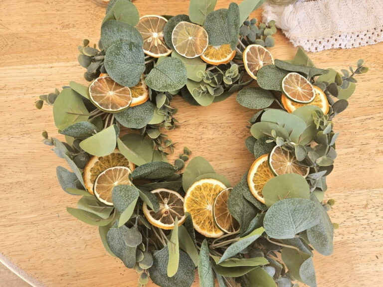 Homemade wreath with dried citrus on a table.