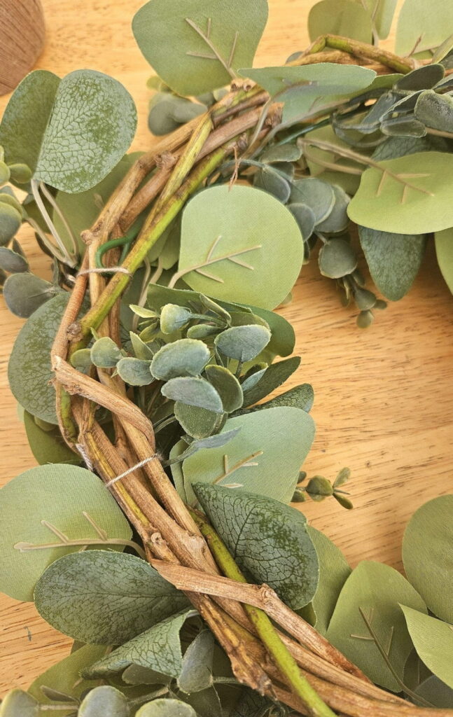 Adding faux garland to wreath.