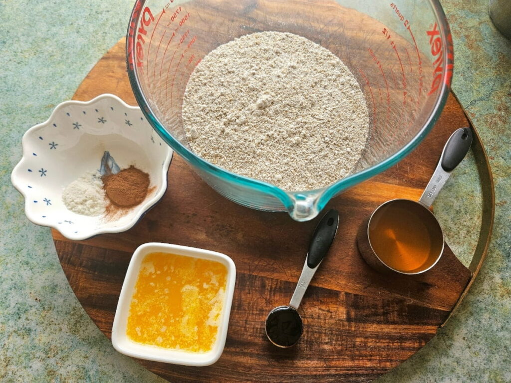 Blended oats, honey, cinnamon, black stral molasses and butter on a cutting board.