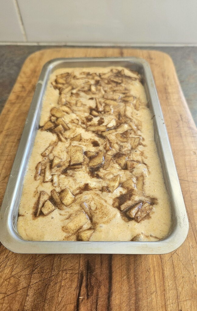 Apple bread batter in a bread pan ready to be baked.
