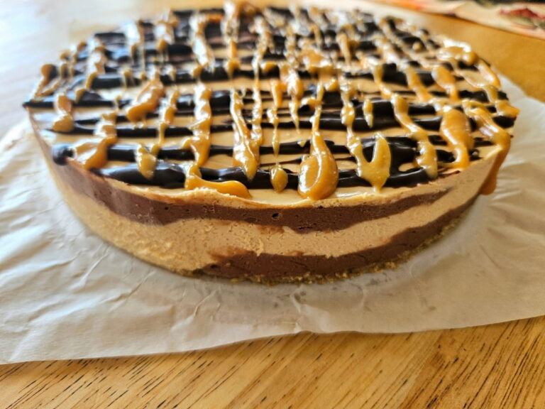 Unbaked chocolate peanut butter chocolate cheesecake on a bench.