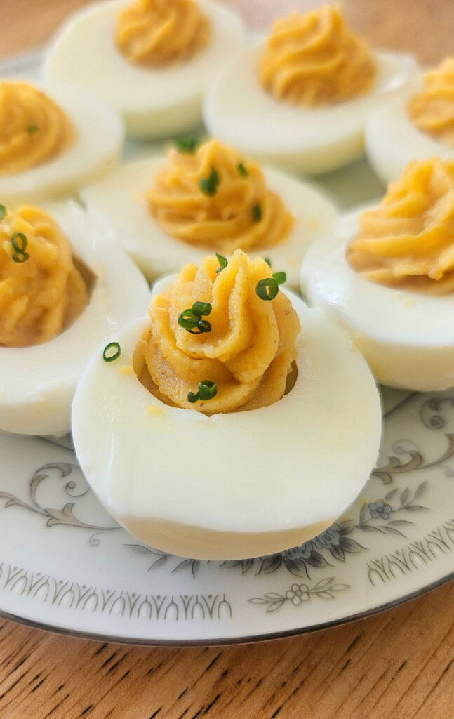 Curried deviled eggs sliced on a plate.