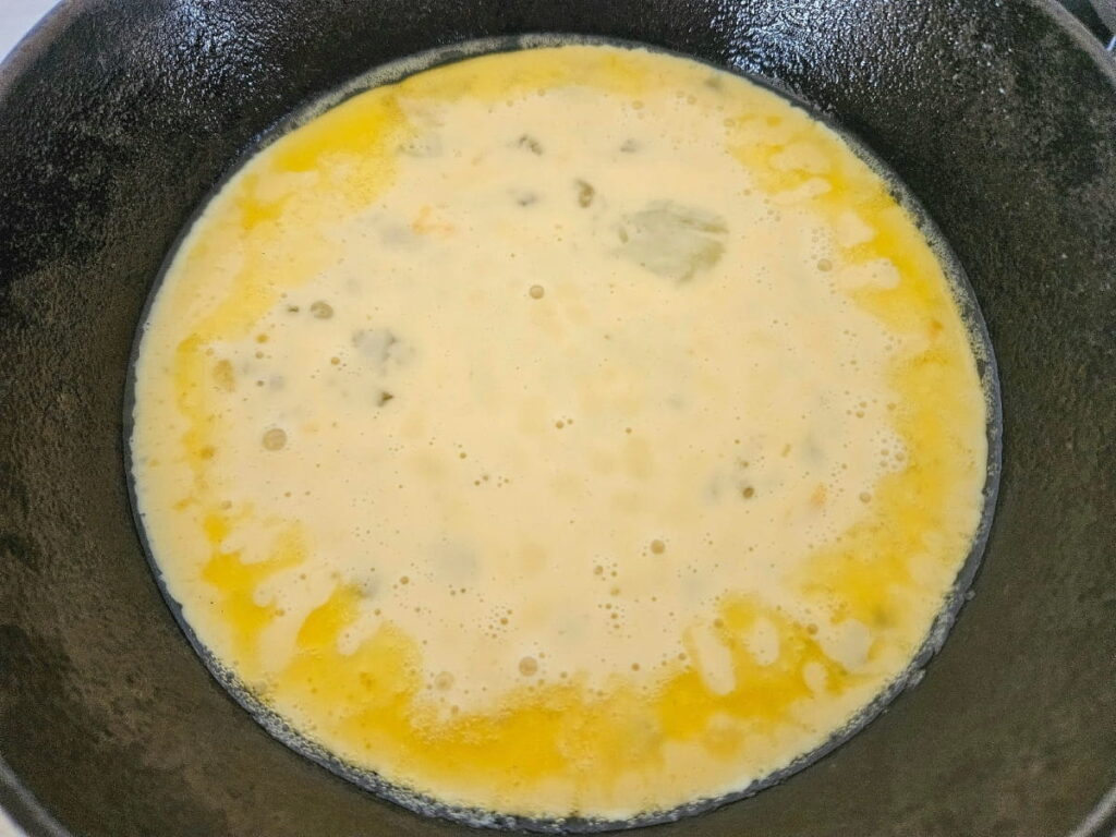 Cooking omelette in a cast iron pan.